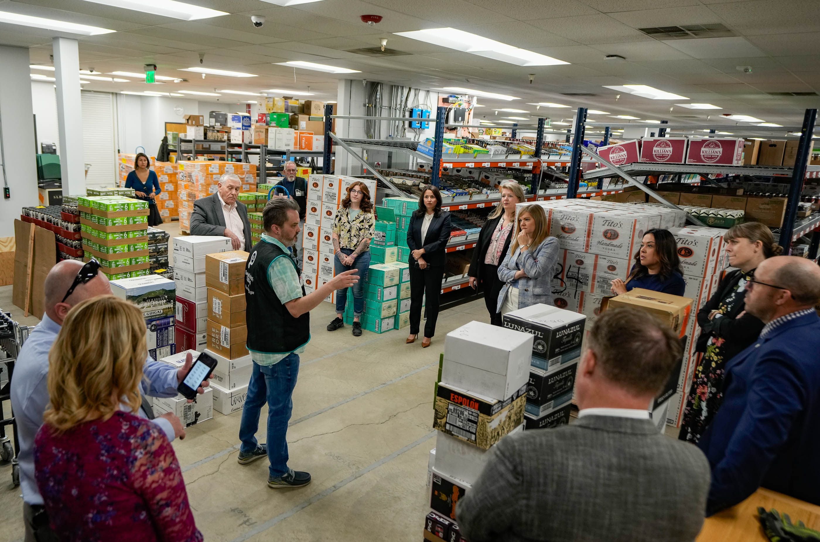 (Francisco Kjolseth  |  The Salt Lake Tribune) Ryan Hill, center, store manager for the Park City Club liquor store that serves as a warehouse for licensed bars and restaurants in the area, gives a tour to the liquor commission on Thursday, April 25, 2024. The roof collapsed at the state liquor store from the weight of snow last year.  