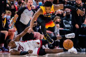 (Trent Nelson  |  The Salt Lake Tribune) Utah Jazz guard Donovan Mitchell (45) leaps over Miami Heat center Bam Adebayo (13) in pursuit of a loose ball as the Utah Jazz host the Miami Heat, NBA basketball in Salt Lake City on Saturday, Nov. 13, 2021.