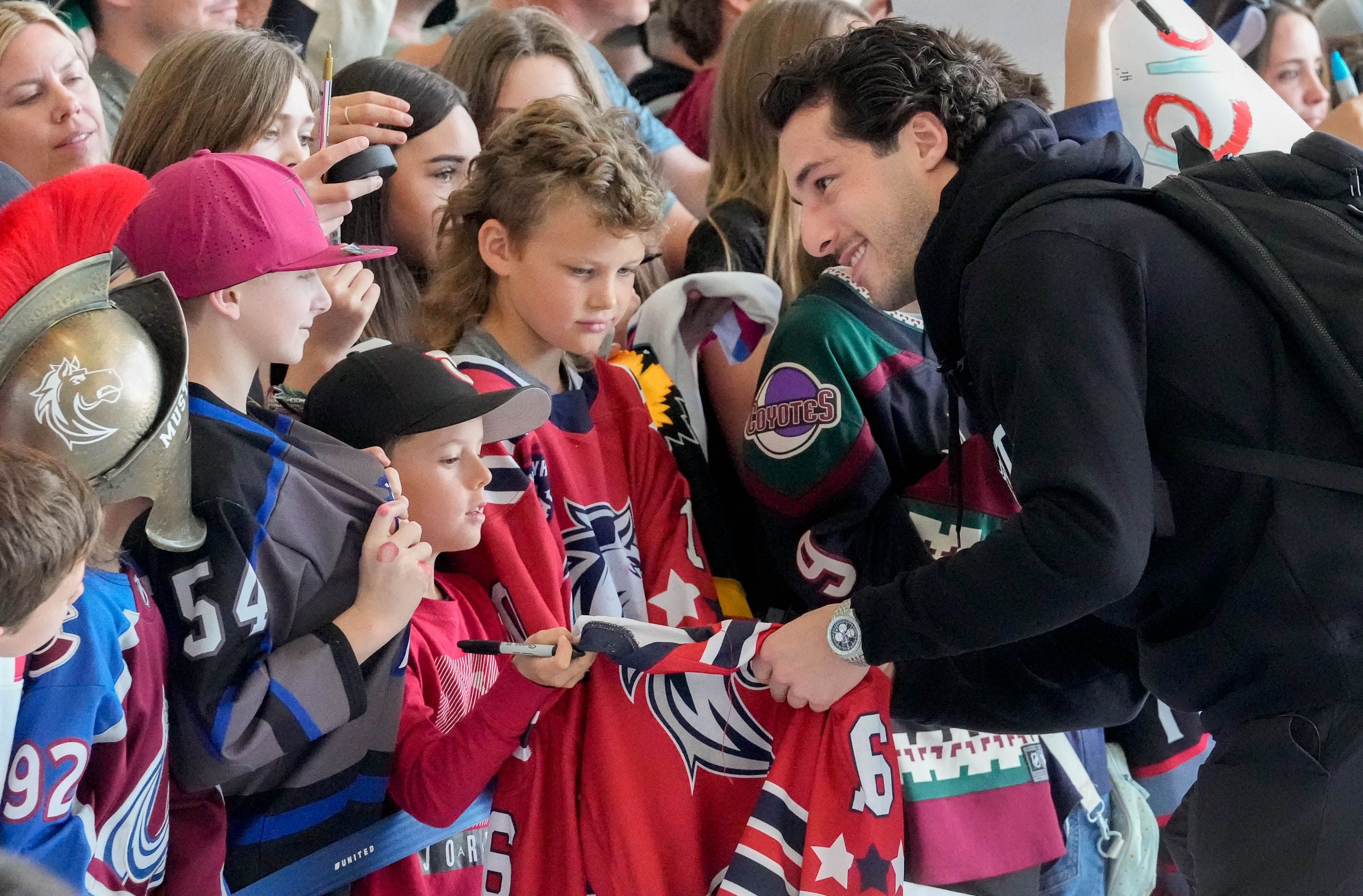 (Francisco Kjolseth  |  The Salt Lake Tribune) Hockey player Sean Durzi signs autographs for young fans for the airport arrival of the new NHL team in Salt Lake City on Wednesday, April 24, 2024.