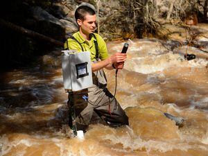 (Trent Nelson  |  The Salt Lake Tribune)  Ben Abbott, Assistant Professor of Ecosystem Ecology at BYU, checks the status of a water monitoring station on Peteetneet Creek in Payson Canyon on Thursday April 25, 2019.