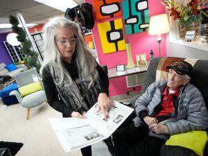 (Francisco Kjolseth | The Salt Lake Tribune) Kim Kanell Nielsen overlooks old store ads alongside her father, Plato Kanell, 95, on Thursday, Dec. 29, 2022, as the family business Kanell’s Furniture Source, which has specialized in mid-century modern furniture in Salt Lake City, nears closing.