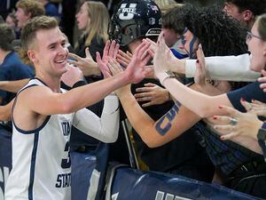 (Eli Lucero/The Herald Journal via AP) Utah State guard Steven Ashworth celebrates with fans after defeating Bradley in an NCAA college basketball game Friday, Nov. 11, 2022, in Logan, Utah.