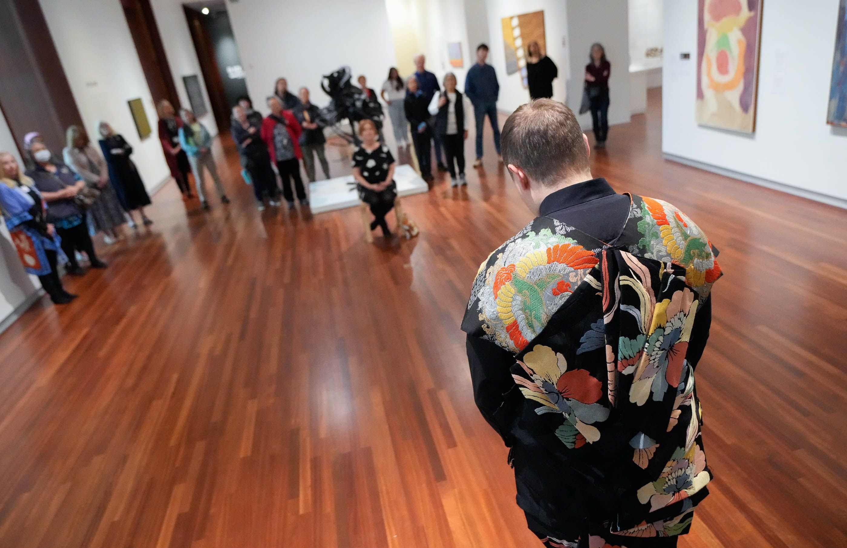 (Francisco Kjolseth | The Salt Lake Tribune) Opera singer Sam Plumb wears a 1930’s Kyoto vest made from two obi’s, a broad sash worn around the waist of a Japanese kimono as part of a new exhibit at the Utah Museum of Fine Arts on Friday, May 3, 2024. Classically trained singer Plumb, delivers the spontaneous “gift of song” to a visitor singing a piece by Franz Schubert. 