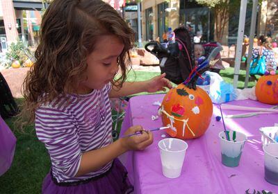 (The Gateway) A girl decorates a jack-o-lantern at the 2018 Pumpkin Festival at The Gateway. The 2022 edition is set for Oct. 22, at The Gateway's Olympic Legacy Fountain, at 50 S. Rio Grande St., Salt Lake City.