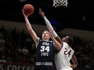 Utah State forward Justin Bean (34) shoots next to Saint Mary's forward Malik Fitts (24) during the first half of an NCAA college basketball game in Moraga, Calif., Friday, Nov. 29, 2019. (AP Photo/Jed Jacobsohn)
