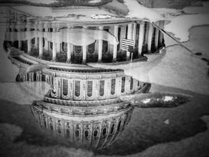 (Mark Peterson | The New York Times)
The U.S. Capitol reflected in a puddle in Washington on Jan. 6, 2022.