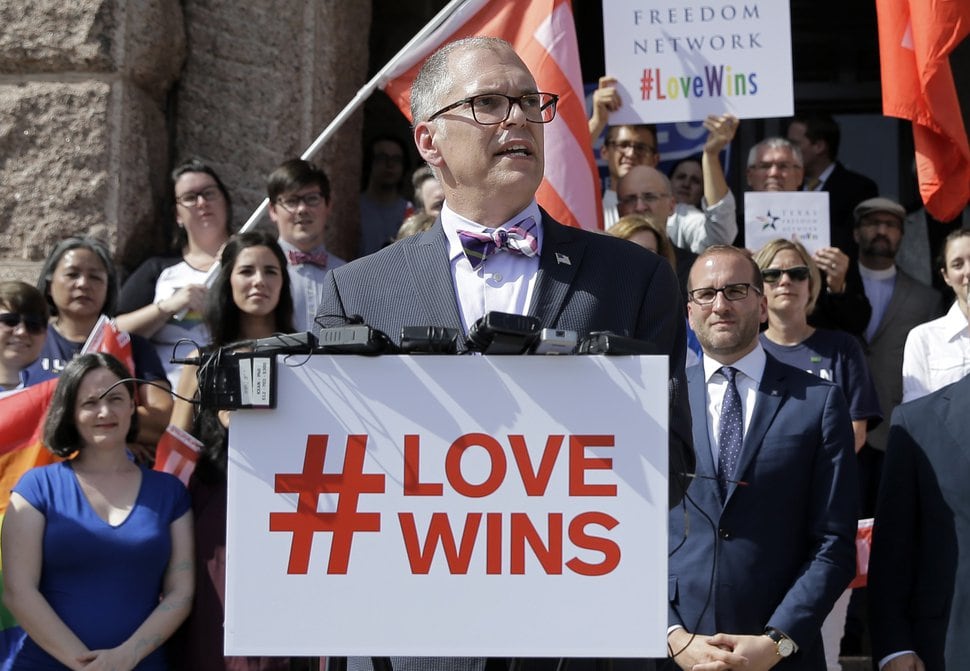 FILE - In this June 29, 2015 photo, Jim Obergefell, the named plaintiff in the Obergefell v. Hodges Supreme Court case that legalized same sex marriage nationwide, is backed by supporters of the courts ruling on same-sex marriage on the step of the Texas Capitol during a rally in Austin, Texas. The Supreme Court declared that same-sex couples have a right to marry anywhere in the United States. It was 2004 when Massachusetts became the first state to allow same-sex couples to marry. Eleven years later, the Supreme Court has now ruled that all those gay marriage bans must fall and same-sex couples have the same right to marry under the Constitution as everyone else. (AP Photo/Eric Gay)