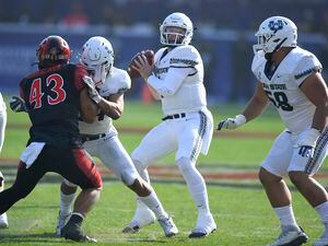 (John McCoy | AP) Utah State quarterback Logan Bonner (1) drops back to pass as Utah State linebacker Tyson Chisholm (43) rushes in the first half during an NCAA college football game for the Mountain West Conference Championship, Saturday, Dec. 4, 2021, in Carson, Calif.