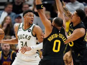 Utah Jazz's Talen Horton-Tucker (0) and Juan Toscano-Anderson, right, defend against Milwaukee Bucks forward Giannis Antetokounmpo (34) during the first half of an NBA basketball game Friday, March 24, 2023, in Salt Lake City. (AP Photo/Rick Bowmer)