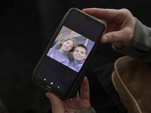 (Emile Ducke | The New York Times) 

Viktoria Borysenko shows a picture of her son, Bohdan, 12, with Daria, the daughter of her sister-in-law, Nadia Borysenko, on her phone in Balakliya, Ukraine, Nov. 4, 2022. When Russians occupied the city, they took the women's children to a summer camp and have not returned them.