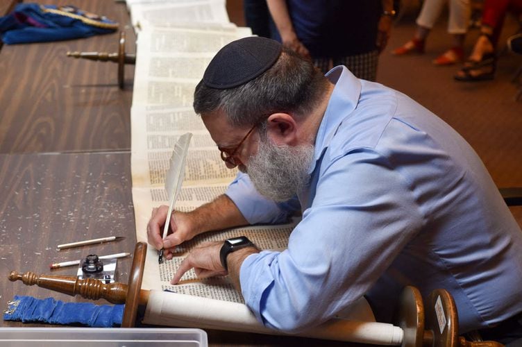 Rabbi Moshe Druin, a sofer, or Jewish text expert, restores a scroll of the Torah belonging to Congregation Kol Ami using a turkey feather quill at the synagogue in Salt Lake City on Monday, July 18, 2022.