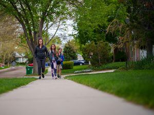 (Trent Nelson  |  The Salt Lake Tribune) Lindsay Godsey walks her children to school in Holladay on Tuesday, May 10, 2022. Godsey, like many other parents who live on the east side of the Salt Lake Valley, has seen enrollment at her children’s elementary school dwindle over the last five years.