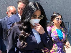 (Lawrence Neumeister | AP) Jennifer Shah, center, of "The Real Housewives of Salt Lake City," touches her face mask as she leaves Manhattan federal court after pleading guilty to wire fraud conspiracy in New York, Monday July 11, 2022.