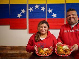 (Trent Nelson  |  The Salt Lake Tribune) Patricia Quiñonez and Fabian Rapalino with the Venezuelan food they'll be having this holiday season, at Arempa's in Salt Lake City on Wednesday, Dec. 22, 2021. On the plate, hallaca (wrapped meat and dough), pernil (slow-roasted pork), cachito (bread and ham), and a potato chicken salad.
