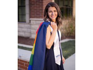 (Hope Orr) Jillian Orr poses in her graduation gown for Brigham Young University on Tuesday, April 26, 2022. Her sister, Rachel Orr, sewed a Pride flag inside of it for Jillian to express her identity on stage after years of feeling like she had to hide being bisexual at the church-run school.