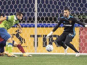 The cross to Seattle Sounders' Jordan Morris leads to the first goal of the match, as Morris beats Real Salt Lake goalkeeper Andrew Putna on the shot during the first half of an MLS soccer match Wednesday, Oct. 7, 2020, in Seattle. (Dean Rutz/The Seattle Times via AP)