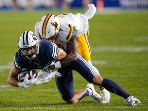 (Francisco Kjolseth | The Salt Lake Tribune) Brigham Young Cougars wide receiver Brayden Cosper (20) is taken down by Wyoming Cowboys cornerback Jakorey Hawkins (7) in football action between the Brigham Young Cougars and the Wyoming Cowboys at LaVell Edwards Stadium in Provo, on Saturday, Sept. 24, 2022.