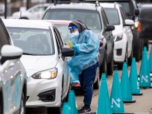 (Leah Hogsten | The Salt Lake Tribune) A steady line of vehicles filled with multiple people waiting to be tested for COVID-19 are tended to by members of the Utah Department of Health at the Cannon Health Building, Dec. 27, 2021.