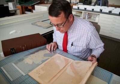 (The Church of Jesus Christ of Latter-day Saints)
Robin Scott Jensen, co-editor of a new volume of the Joseph Smith Papers that focuses on the original manuscript of the Book of Mormon, looks at several pages from the original manuscript in the Church History Library on Jan. 19, 2022.