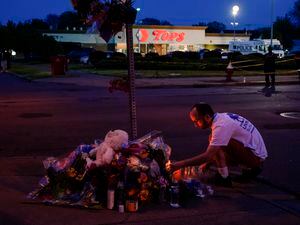 (Matt Rourke | AP Photo) A person pays his respects outside the scene of a shooting at a supermarket, in Buffalo, N.Y., Sunday, May 15, 2022.