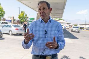 (Rick Egan | The Salt Lake Tribune)  Rep. John Curtis talks to the media as motorists line up to fill their tanks with unleaded gas at the price it was this time last year, in Lehi, on Tuesday, July 26, 2022.