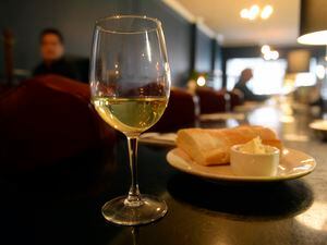 (Al Hartmann  |  Tribune file photo) A glass of wine and plate of bread at a Salt Lake City restaurant in 2017. Utah's liquor commission warned restaurants at an April 27, 2023, meeting that it will be stringent with applications because of a scarcity of restaurant licenses, even with an influx of 30 extra licenses approved by the Utah Legislature that will become available in May 2023.