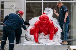 (Rick Egan | The Salt Lake Tribune)  Workers place a new art installation featuring a life-size sumo wrestler, in front of the Mountain West Commercial Real Estate building, previously the KALL Radio 910 broadcast station, on South Temple, in Salt Lake City, on Monday, March 29, 2021.