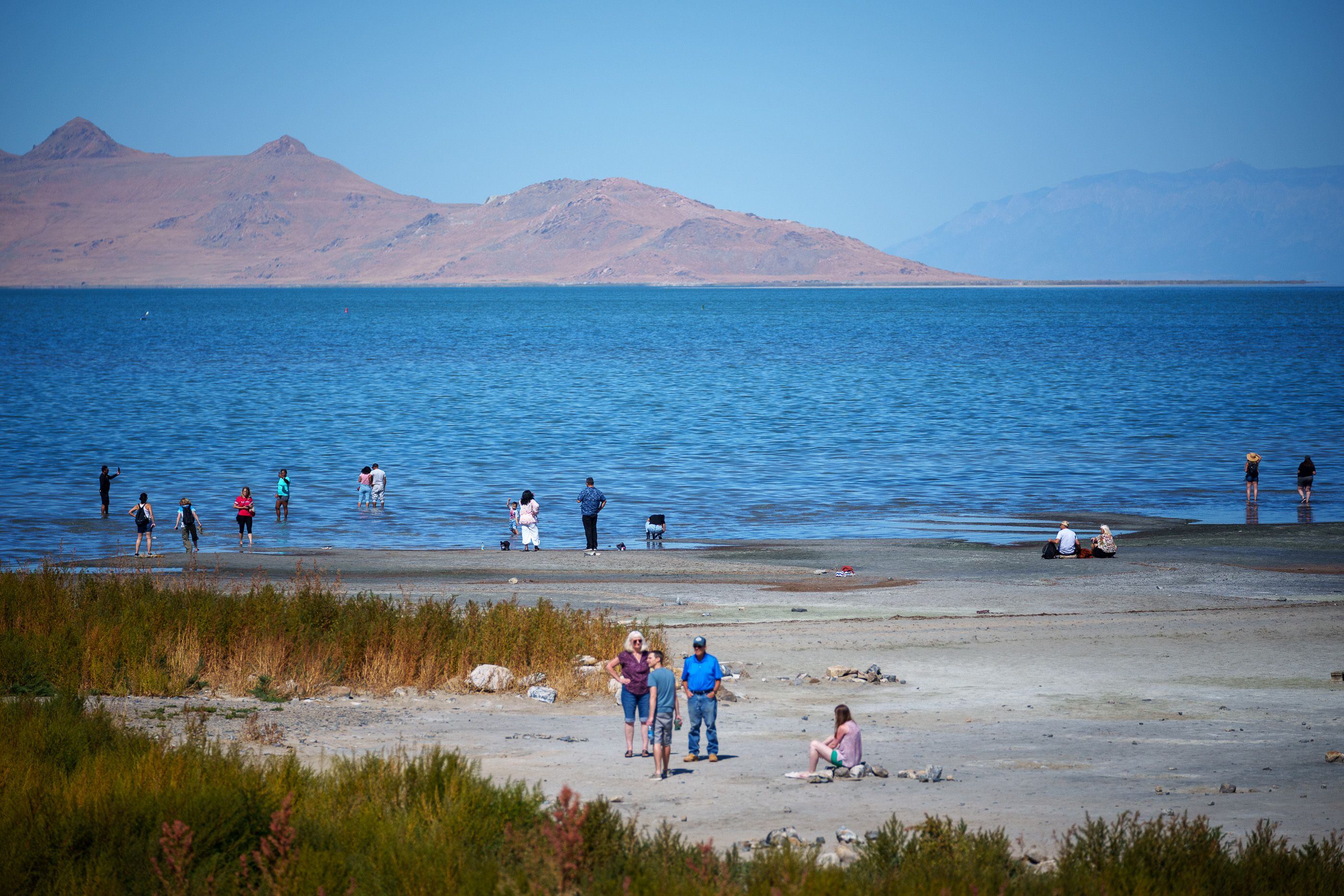 (Trent Nelson  |  The Salt Lake Tribune) People on the shore of the Great Salt Lake in September 2023. Utahns worry about the lake's future and the effects it could have on livability and air quality.