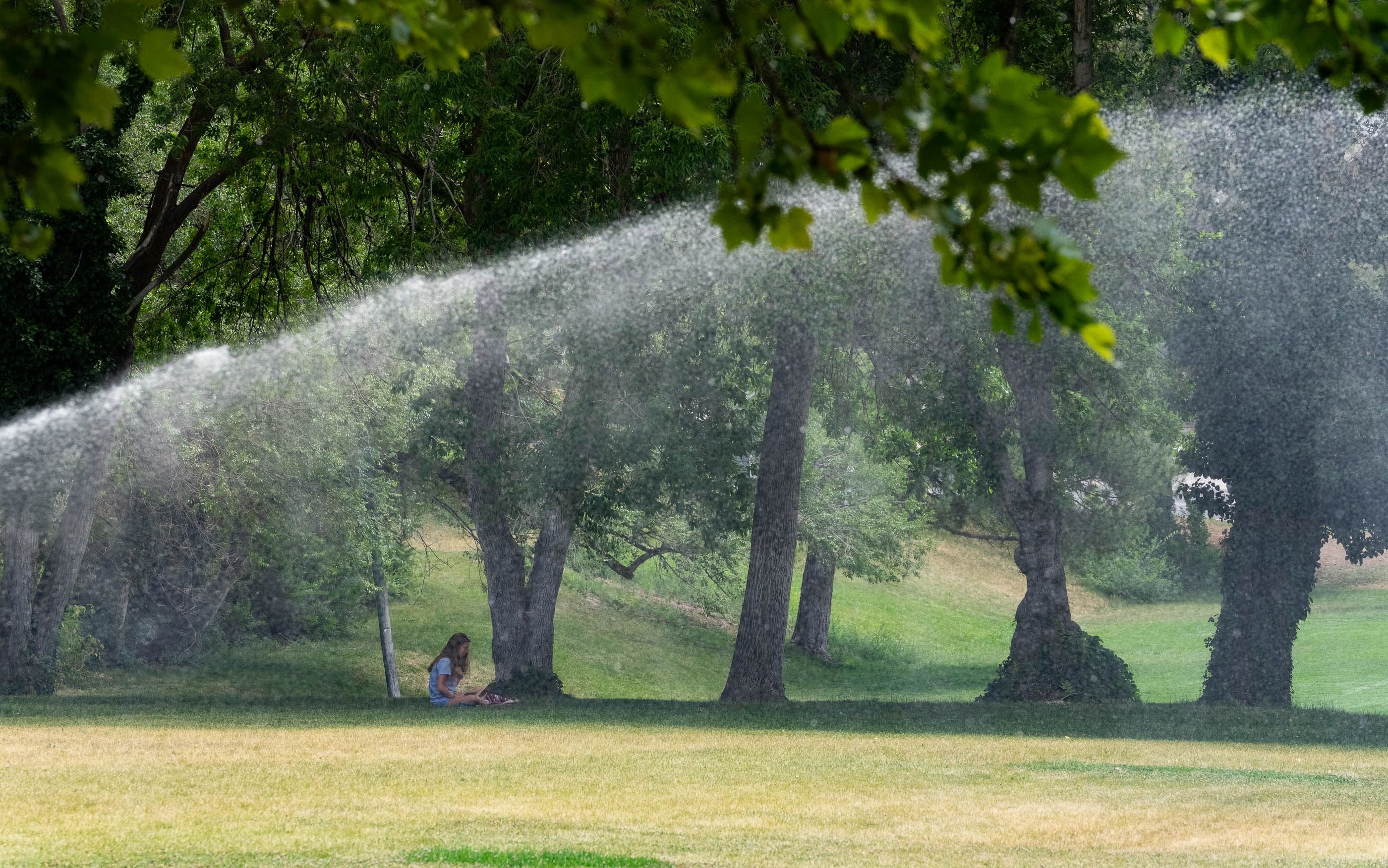 (Francisco Kjolseth | The Salt Lake Tribune) Sprinklers run at Reservoir Park in the middle of the afternoon heat during peak evaporations times on Monday afternoon, July 19, 2021, near the University of Utah campus.