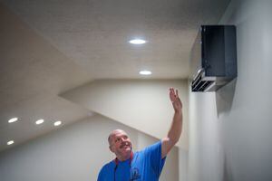 (Trent Nelson  |  The Salt Lake Tribune) Roger Graham reaches up to feel the flow of hot air coming from the electrical heat pump system in his Hooper home on Friday, April 29, 2022.