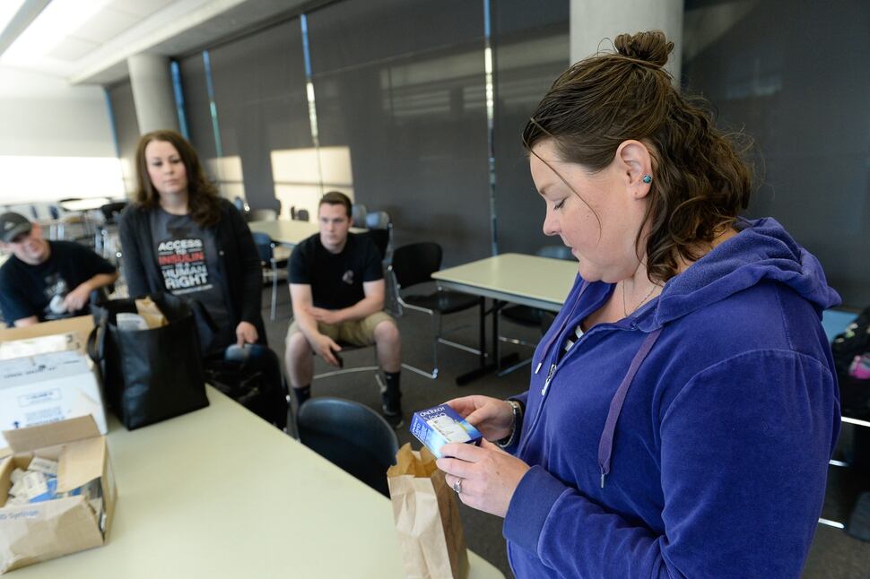 (Francisco Kjolseth | The Salt Lake Tribune) Stephanie Arceneaux, right, looks at a box of testing strips for people with Type 1 diabetes. Arceneux, who has the disease along with her husband and son, joined the Utah chapter of the support group T1 International, and helps deliver donated insulin around northern Utah.
