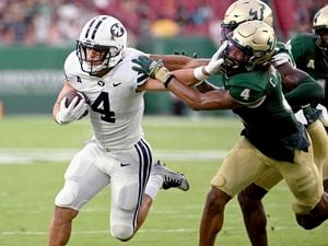 (Jason Behnken | AP) BYU running back Lopini Katoa (4) runs the ball against South Florida safety Christian Williams (4) during the first half of an NCAA football game Saturday, Sept. 3, 2022, in Tampa, Fla.