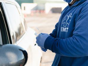 (Rachel Rydalch | The Salt Lake Tribune) EMT, Charles Ledbetter, delivers a COVID-19 test to a patient in their car in Salt Lake City on Thursday, Feb. 3, 2022.