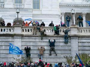 (Jose Luis Magana | The Associated Press)Supporters of President Donald Trump climb the west wall of the U.S. Capitol on Jan. 6, 2021, in Washington. The mob proceeded to breach the Capitol.