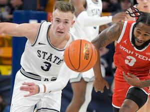 (Eli Lucero | The Herald Journal via AP) Utah State guard Steven Ashworth, left, and Utah Tech guard Cameron Gooden chase the ball during the first half of an NCAA college basketball game Thursday, Dec. 1, 2022, in Logan, Utah.