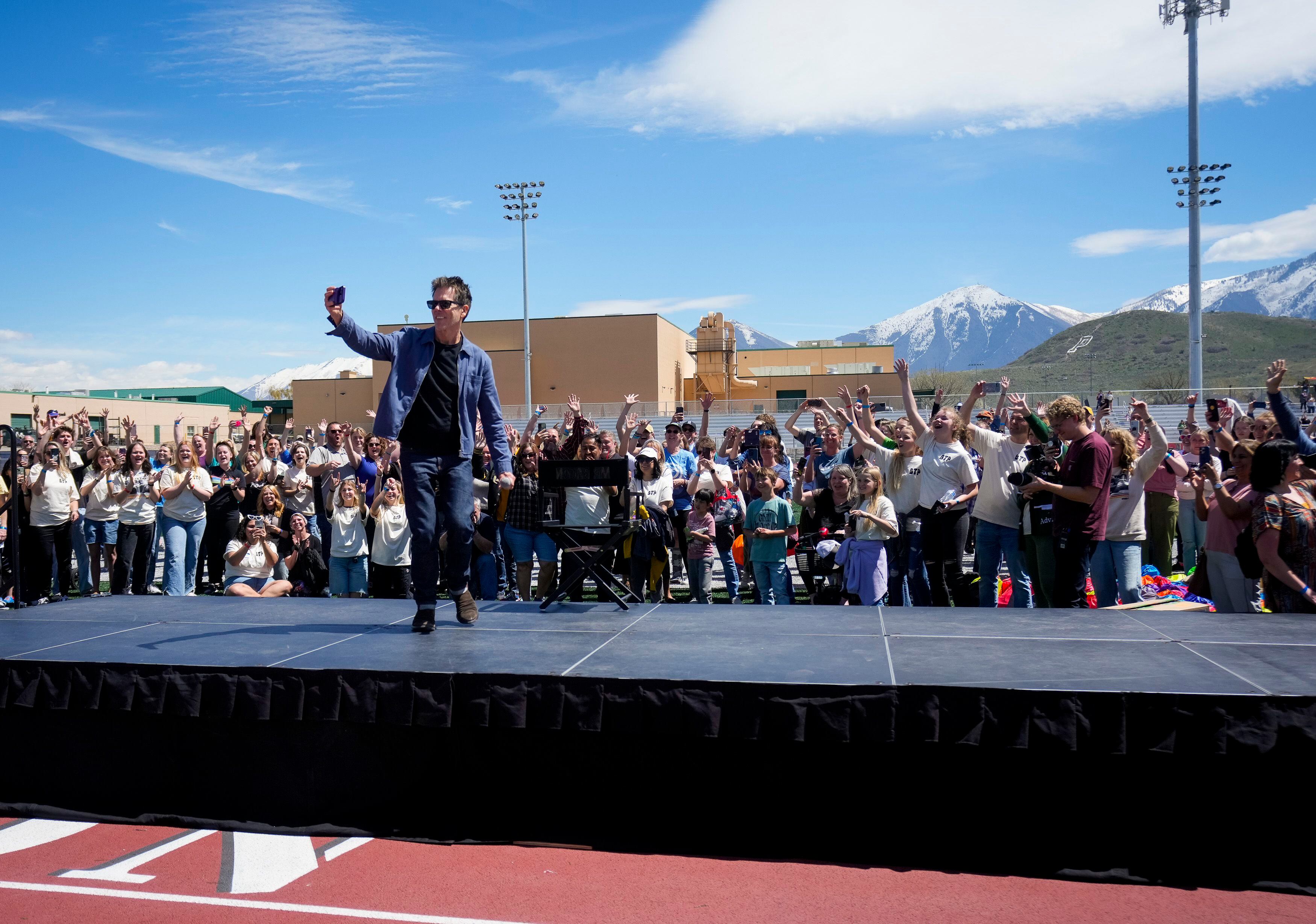 (Bethany Baker  |  The Salt Lake Tribune) Kevin Bacon records a video with the crowd, playing into the "six degrees from Kevin Bacon" game, following a charity event to commemorate the 40th anniversary of the movie "Footloose" on the football field of Payson High School in Payson on Saturday, April 20, 2024.