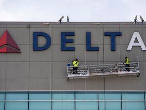 (Rick Egan | The Salt Lake Tribune)  Workers put the the Delta back on the building, on Thursday, May 25, 2023.