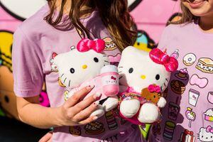 (Sanrio) Fans hold plush toys of Sanrio's Hello Kitty in front of a Hello Kitty Cafe truck. One of the touring trucks is scheduled to land at Murray's Fashion Place Mall on Saturday, May 14, 2022.