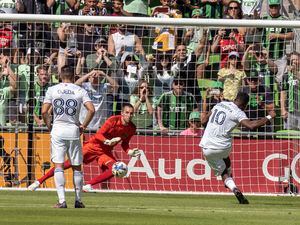 Real Salt Lake forward Sergio Cordova (10) scores a goal on a free kick while defended by Austin FC goalie Brad Stuver, center, during the first half an MLS playoff soccer match, Sunday, Oct. 16, 2022, in Austin, Texas. (AP Photo/Michael Thomas)