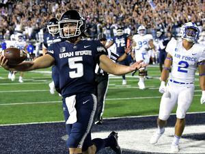 (Eli Lucero | The Herald Journal via AP) Utah State quarterback Cooper Legas (5) celebrates after scoring a touchdown against Air Force during the second half of an NCAA college football game Saturday, Oct. 8, 2022, in Logan.
