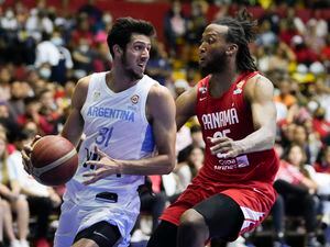 Argentina's Leandro Nicolas Bolmaro, left, looks to drive against Panama's Akil Mitchell during their FIBA Americas qualifiers for the 2023 Basketball World Cup at Roberto Duran arena in Panama City, Sunday, July 3, 2022. (AP Photo/Arnulfo Franco)