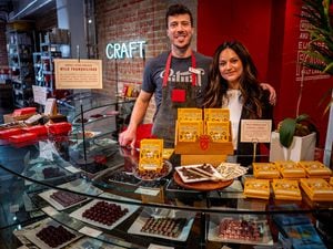 (Trent Nelson  |  The Salt Lake Tribune) Matt and Yelena Caputo, standing with a display of Wild Tranquilidad chocolate bars at Caputo's Market & Deli in downtown Salt Lake City on Thursday, May 11, 2023. The bars, produced by Caputo's and Ritual Chocolate, are made with wild cacao harvested in Bolivia.