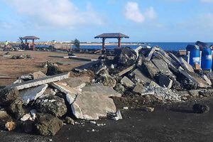 This photo provided by Broadcom Broadcasting shows a damaged area in Nuku'alofa, Tonga, Thursday, Jan. 20, 2022, following Saturday's volcanic eruption near the Pacific archipelago. The first flight carrying fresh water and other aid to Tonga was finally able to leave Thursday after the Pacific nation's main airport runway was cleared of ash left by the eruption. (Marian Kupu/Broadcom Broadcasting via AP) 