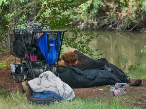 (Leah Hogsten | The Salt Lake Tribune) A couple living on the bank of the Jordan River in Cottonwood Park in August. Salt Lake City deploys a rapid intervention team to try to get people into shelters and services.