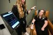 (Bethany Baker  |  The Salt Lake Tribune) Tia Johnson, left, a nurse practitioner, holds up a tablet showing the vitals of Andrea Swensen, a physician's assistant student, as they demonstrate how a client is continuously monitored during a session at Anew Therapy, a ketamine clinic, in Midvale on Wednesday, April 24, 2024.