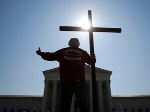 (Patrick Semansky | AP) Protester holds a cross outside the Supreme Court in 2020. Growing Christian nationalism is getting pushback in north Idaho.