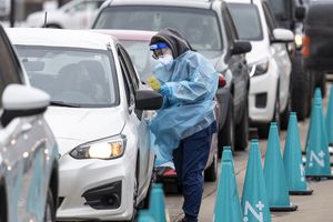 (Leah Hogsten | The Salt Lake Tribune) A steady line of vehicles filled with multiple people waiting to be tested for COVID-19 are tended to by members of the Utah Department of Health at the Cannon Health Building, Dec. 27, 2021.