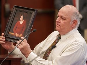 (Trent Nelson  |  The Salt Lake Tribune) Kent Mayne holds a photo of his daughter Amanda, while appearing before the Senate Judiciary, Law Enforcement, and Criminal Justice Committee in Salt Lake City on Tuesday, Jan. 24, 2023. Mayne and Lt. Gov. Deidre Henderson spoke in support of a Senate bill beefing up how the state combats domestic violence. Amanda "Mandy" Mayne was shot and killed by her ex-husband in 2022.
