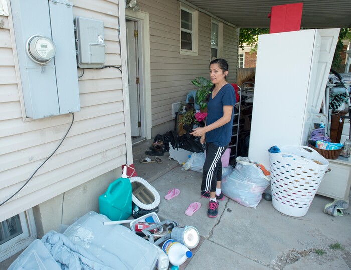 (Rick Egan  |  The Salt Lake Tribune)  Ana Holt takes a look at all of her belongings on the back patio of her home. Nearly everything that was in the basement needs to be thrown away, after sewage water flooded the basement of her home 2100 South. Tuesday, August 1, 2017.