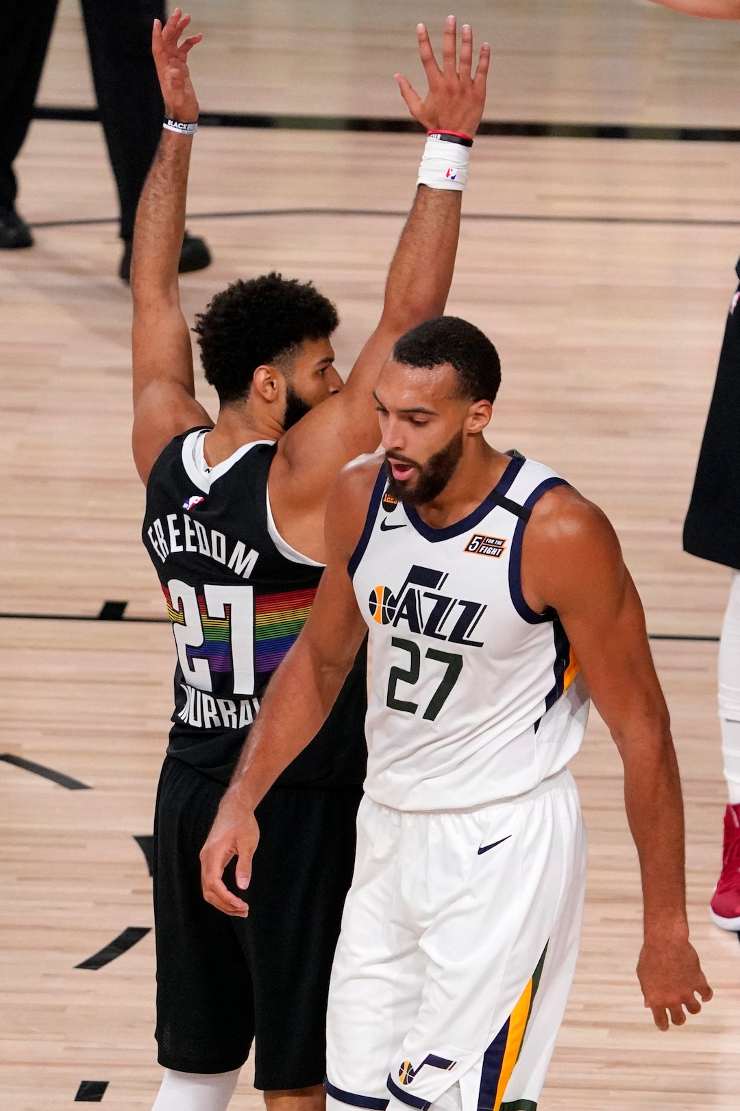 Denver Nuggets' Jamal Murray (27) keeps his arms in position as Utah Jazz's Rudy Gobert (27) walks past after Gobert scored a basket and drew a foul on the play during the second half an NBA first round playoff basketball game, Tuesday, Sept. 1,2020, in Lake Buena Vista, Fla. (AP Photo/Mark J. Terrill)